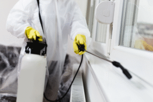exterminator spraying windowsill